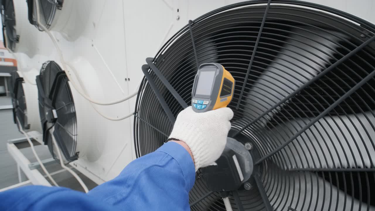 Technician uses a thermal imaging infrared thermometer to check the condensing unit heat exchanger