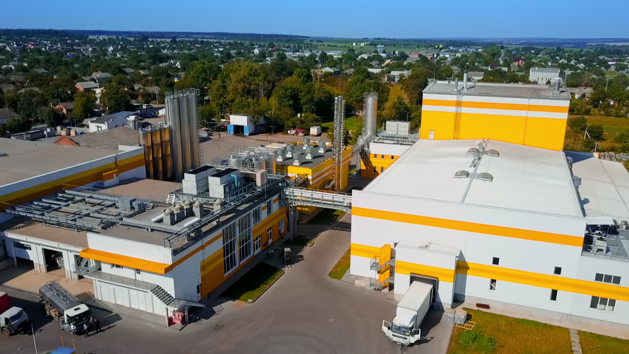Neat territory of a new industrial plant. Rural area in the exuberant greenery on sunny day. Top view.