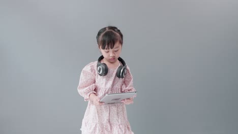 헤드셋을 끼고 디지털 태블릿으로 비디오를 보는 어린이