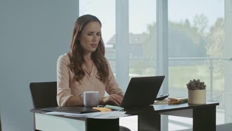 una mujer de negocios cerrando una computadora portátil. una mujer cansada terminando el trabajo en el lugar de trabajo.