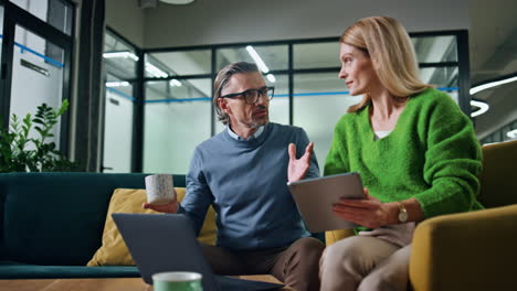 Business-couple-discussing-project-in-office-hall.-Inspired-coworkers-talking