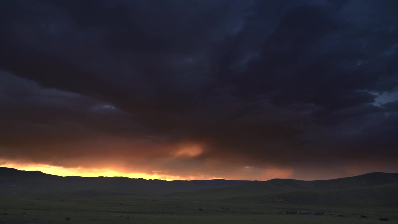Dramatic Storm Clouds Over Rolling Hills at Sunset