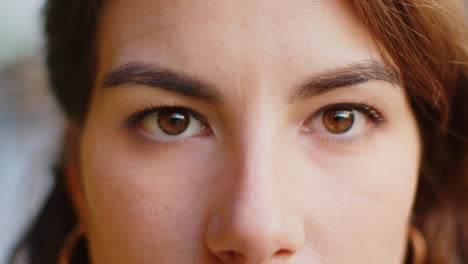 extreme close-up macro portrait of female caucasian girl face woman's brown eyes looking at camera