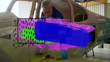 working on aircraft, man with colorful abstract animation overlay in workshop
