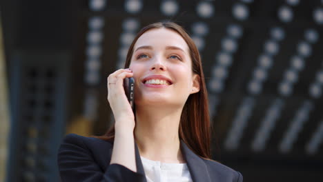 mujer riendo llamando por teléfono móvil al aire libre