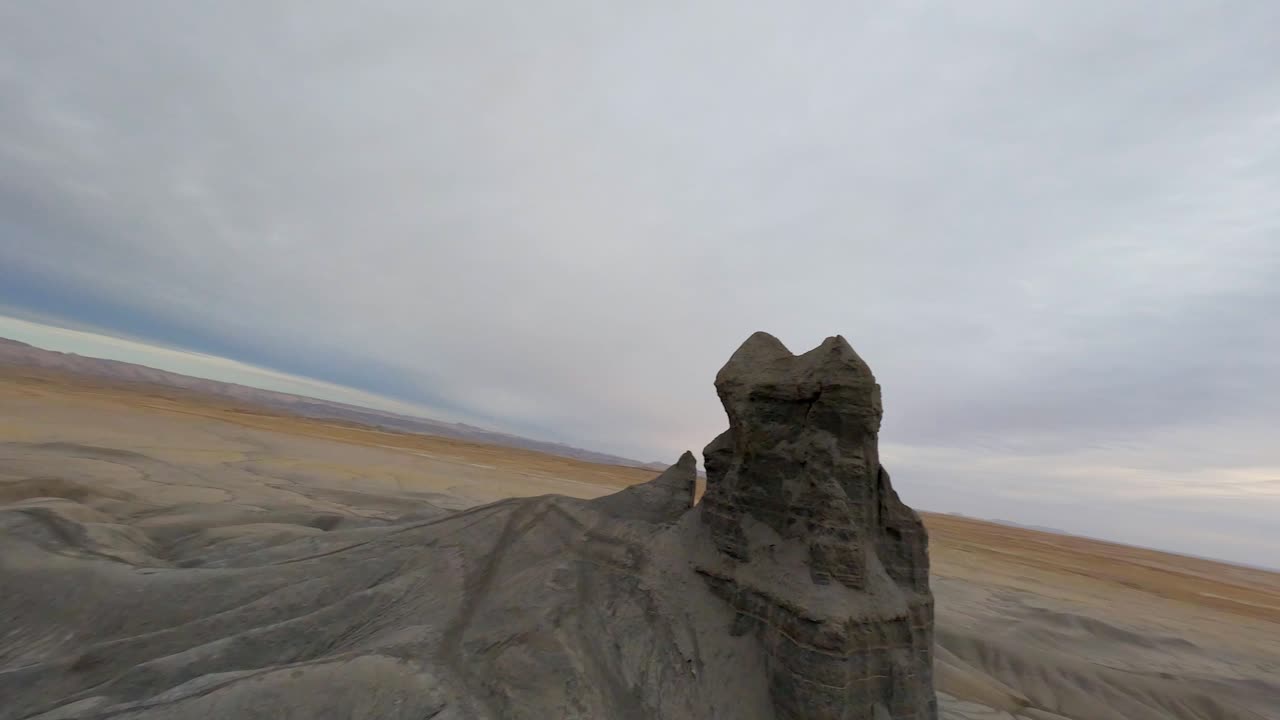 Tepelerde ve kanyonlarda Factory Butte FPV drone geçişi.