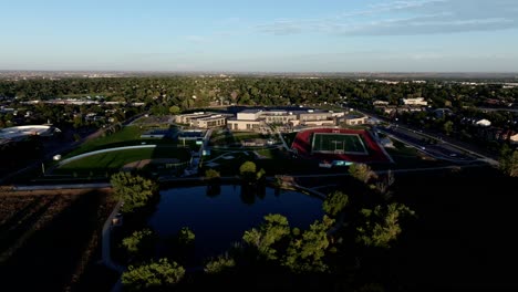 greeley west high school drone establishing shot forward dolly press golden hour cinema quality.