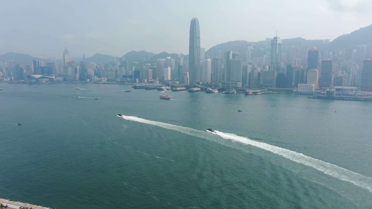 barcos de guardacostas de hong kong rugiendo a través de las aguas abiertas de la bahía, vista aérea