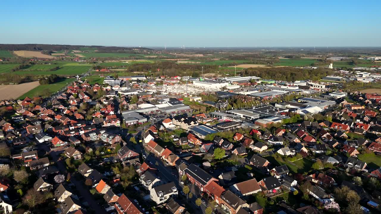 Historic small town with neighborhood, industrial area with factory and companies and agricultural Farm fields in distance. Aerial dolly wide shot. Sunset time in american town in spring season.