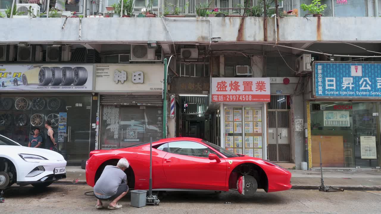 Red Ferrari Having Tire Changed on Busy Hong Kong Street
