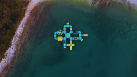 Perspectiva-Aérea-De-Un-Parque-Acuático-Inflable-En-La-Playa-Mediante-Vigilancia-Con-Drones