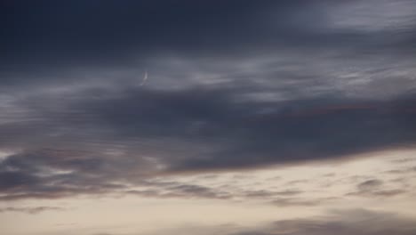crescent moon in a cloudy night sky