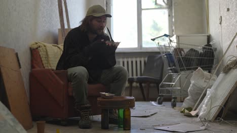 homeless man eating in a derelict apartment