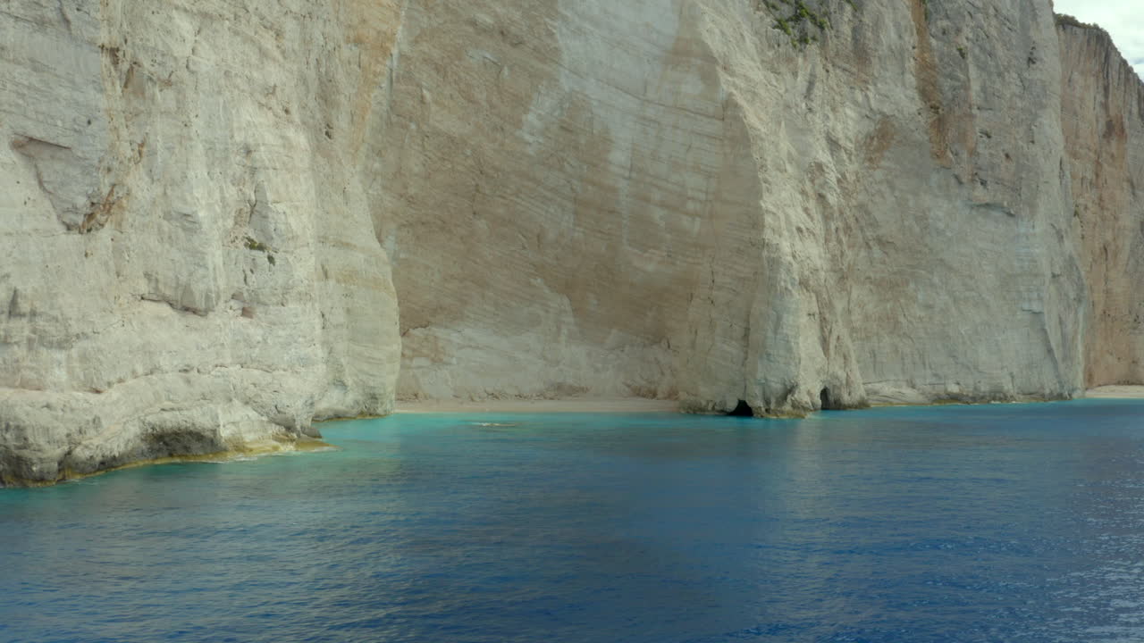 una playa solitaria y desierta con enormes acantilados blancos cerca de la playa navagio en zakynthos, grecia