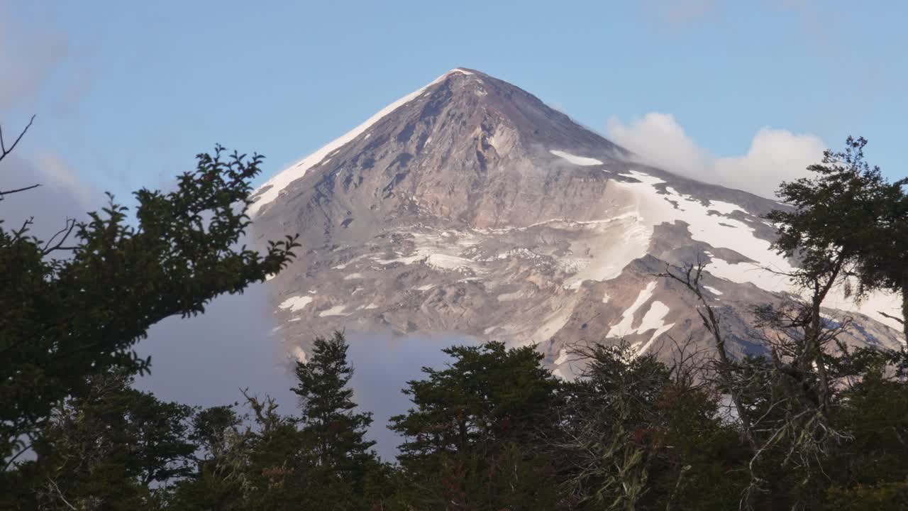Scenic view of Lanin Volcano with trees in the foreground, zoom-in. Lanin National Park, Neuquen, Argentina