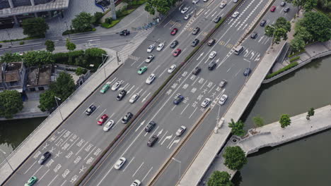 Cars,-taxis-and-public-transport-buses-moving-on-a-highway-in-city-downtown-of-Guangzhou,-China,-Aerial-shot,-Asia