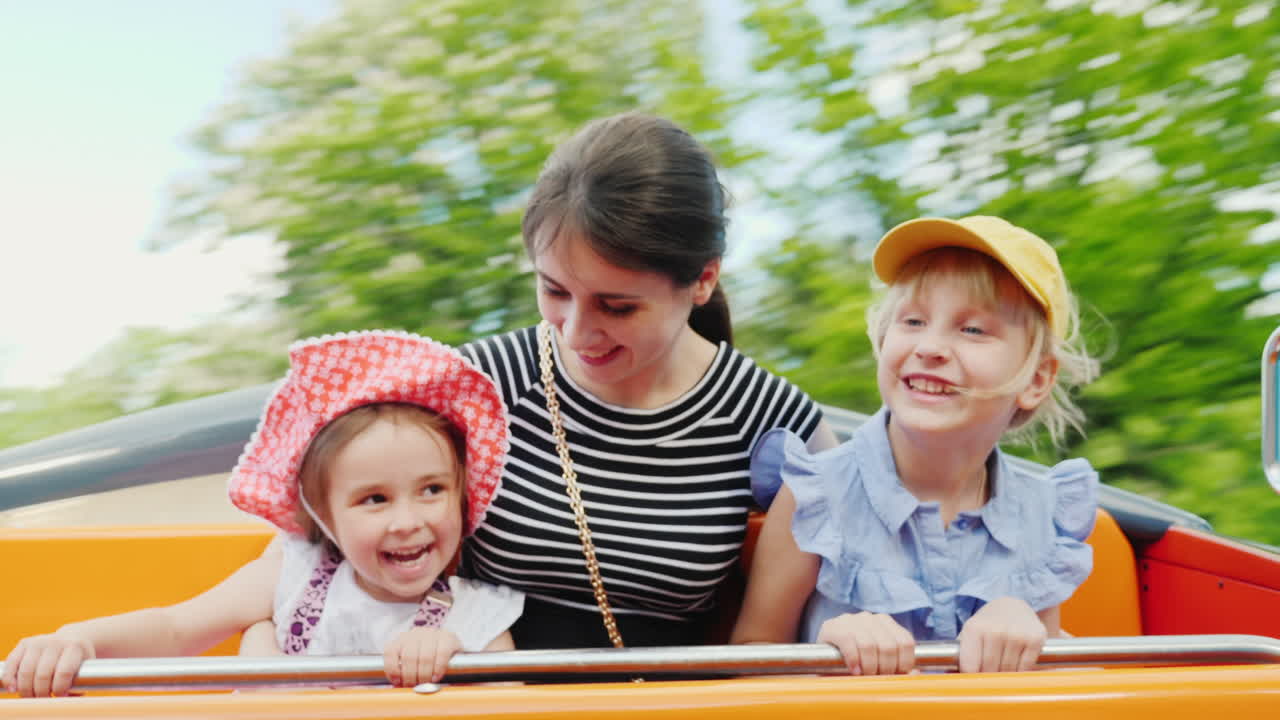 공원 1에서 그네를 타고 두 딸과 함께 행복 한 젊은 어머니