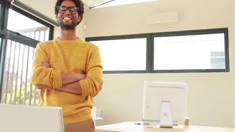 smiling hipster man standing near his desk