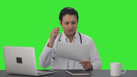 Confused-Indian-doctor-checking-medical-reports-Green-screen