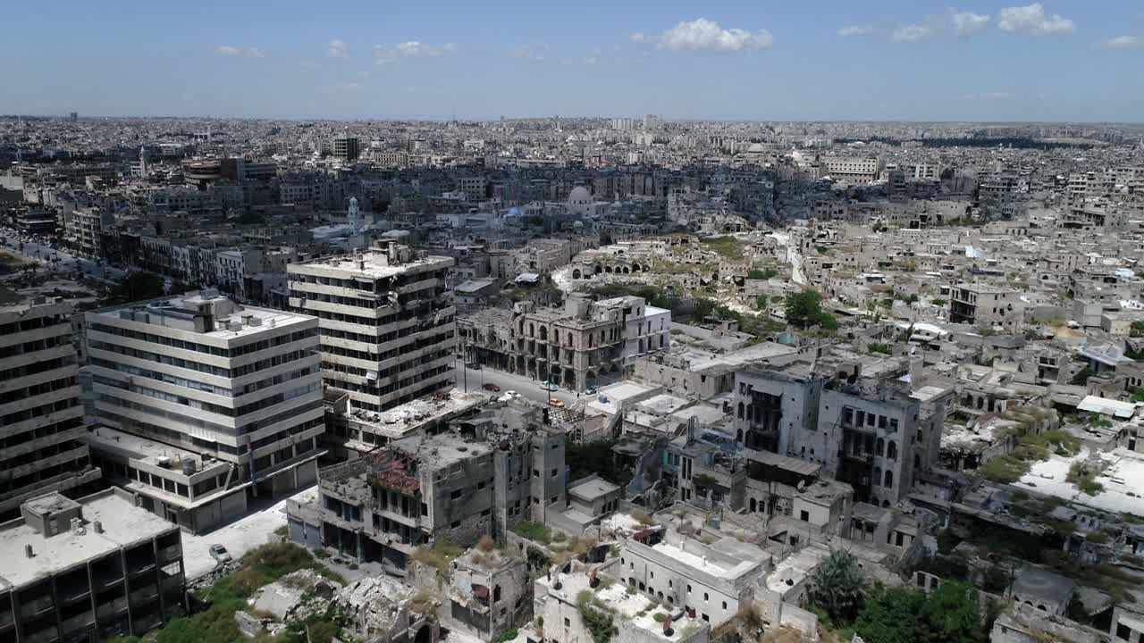 시리아 도시 위를 날아다니는 드론과 도로를 달리는 자동차, 10년 전 내전 이후 여전히 폐허가 된 건물들