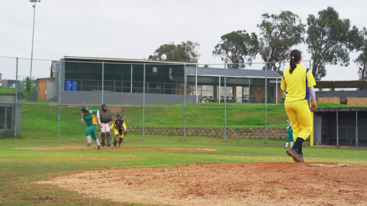 Multiracial female baseball players and male umpire, throwing and hitting the ball on a pitch