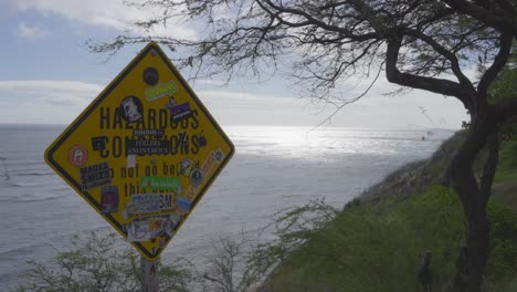 Un-Cartel-Que-Indica-Condiciones-Peligrosas-Cerca-De-Un-Acantilado-En-Diamond-Head-Hawaii-Está-Cubierto-Con-Pegatinas