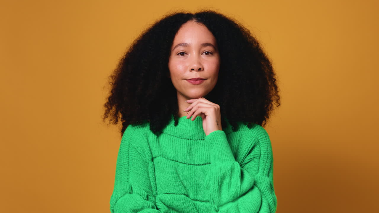 Portrait of a Smiling Woman with Curly Hair in a Green Sweater