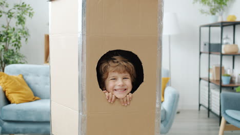 a child playing in a cardboard fort
