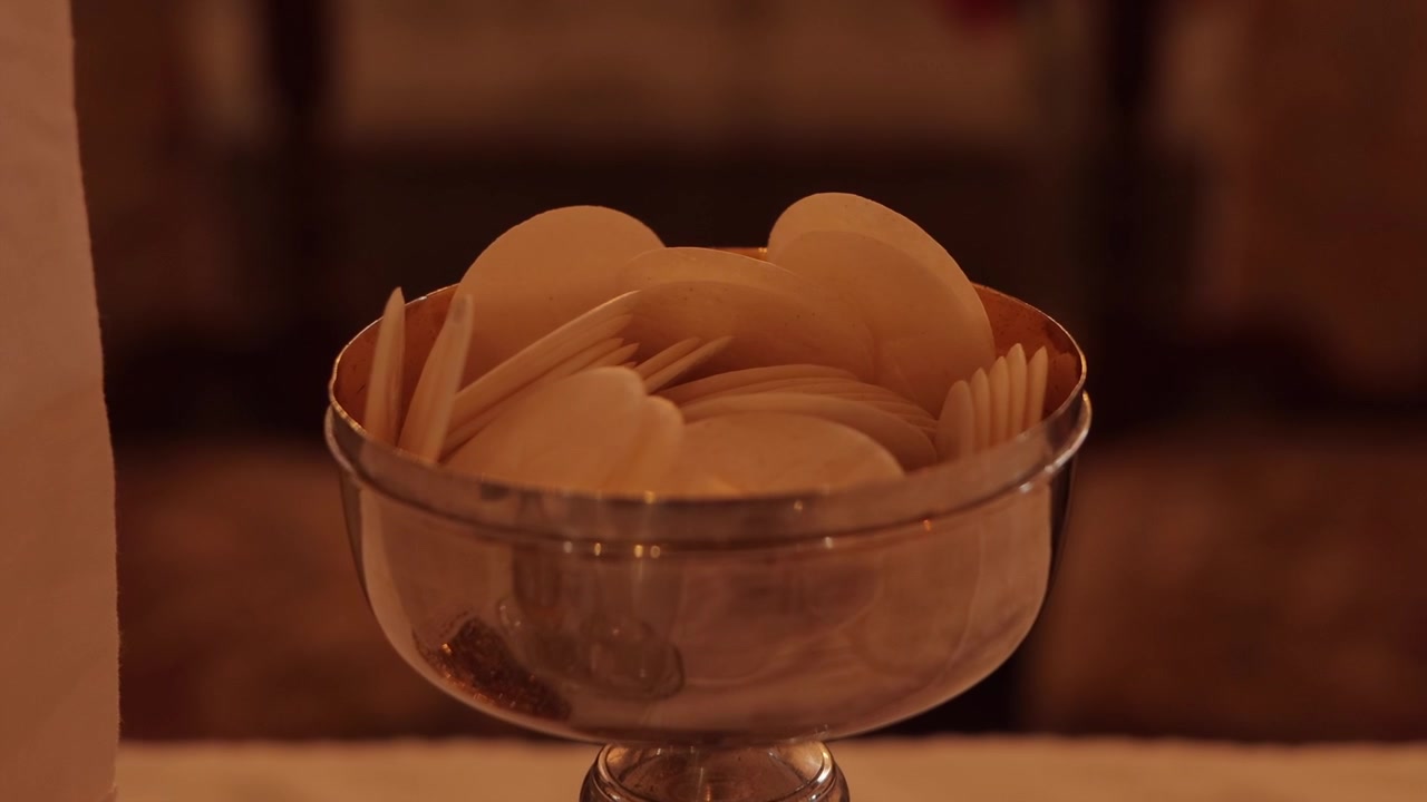 Consecrated bread and wine during a Catholic Mass, symbolizing the Holy Eucharist and the real presence of Christ in a sacred liturgical celebration.