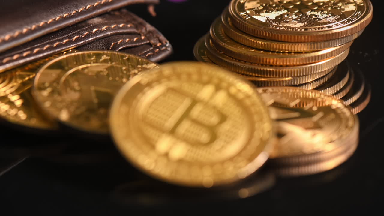 Close view of physical crypto coins spilled out of the wallet, golden Bitcoin