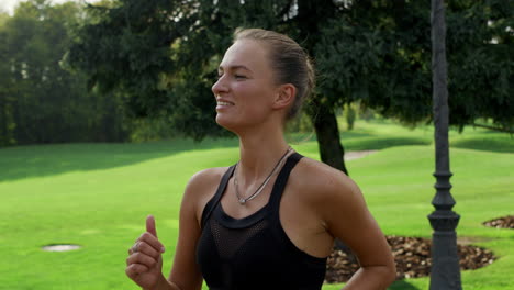 positive woman running in green park. athlete doing cardio workout at morning