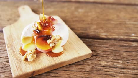 cheese topped with walnut, fruits and sauce