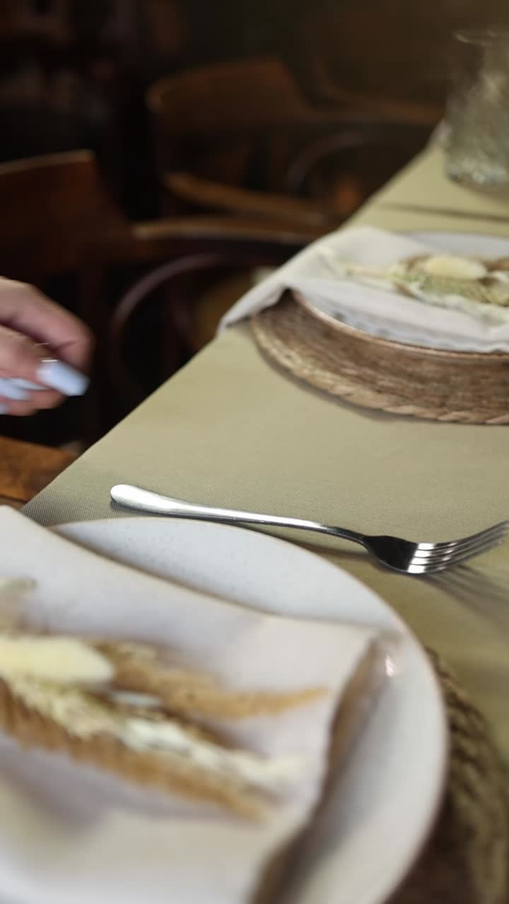 Hand Placing Knife and Fork on an Elegant Dining Table