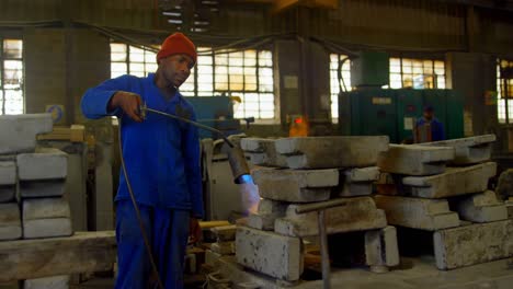 trabajador calentando el molde metálico con soplete en el taller de fundición 4k