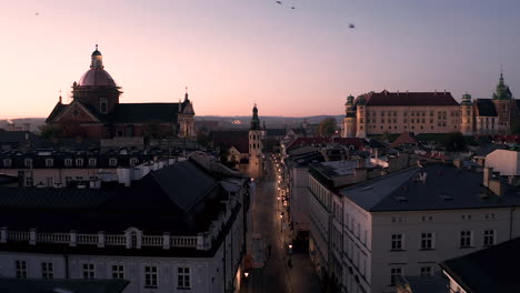 aerial view of old town - tenement houses on grodzka street and wawel castle in krakow , poland during magic sunrise with soft morning light in pink, pastel colors