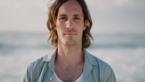 portrait of handsome caucasian man enjoying calm seaside beach looking at camera summer vacation