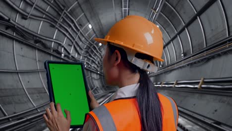 engineer inspecting tunnel with tablet