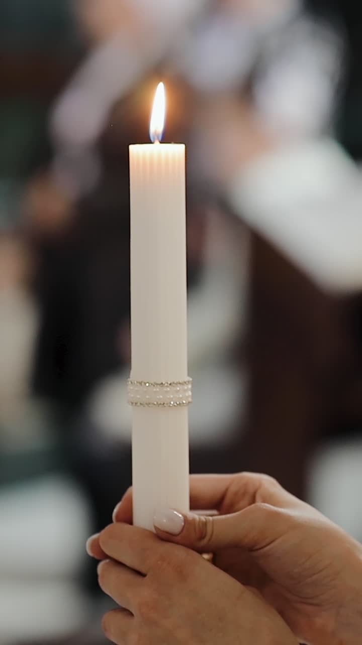 la novia está de pie en la iglesia en la boda y tiene una vela encendida en sus manos