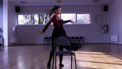 professional female dancer dances around two chairs