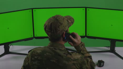 soldado en la sala de control con triple monitor