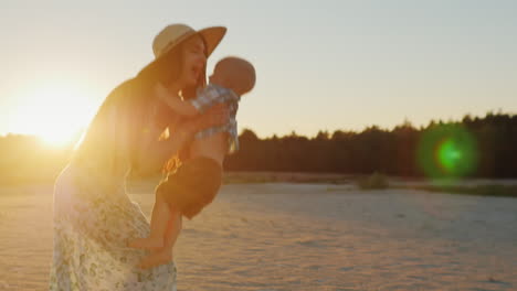 Joven-Madre-Con-Cabello-Largo-Jugando-Con-Su-Hijo-Al-Atardecer-Riendo-Juntos