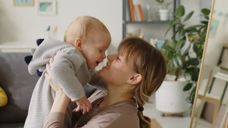 mother kissing baby as he making first steps at home