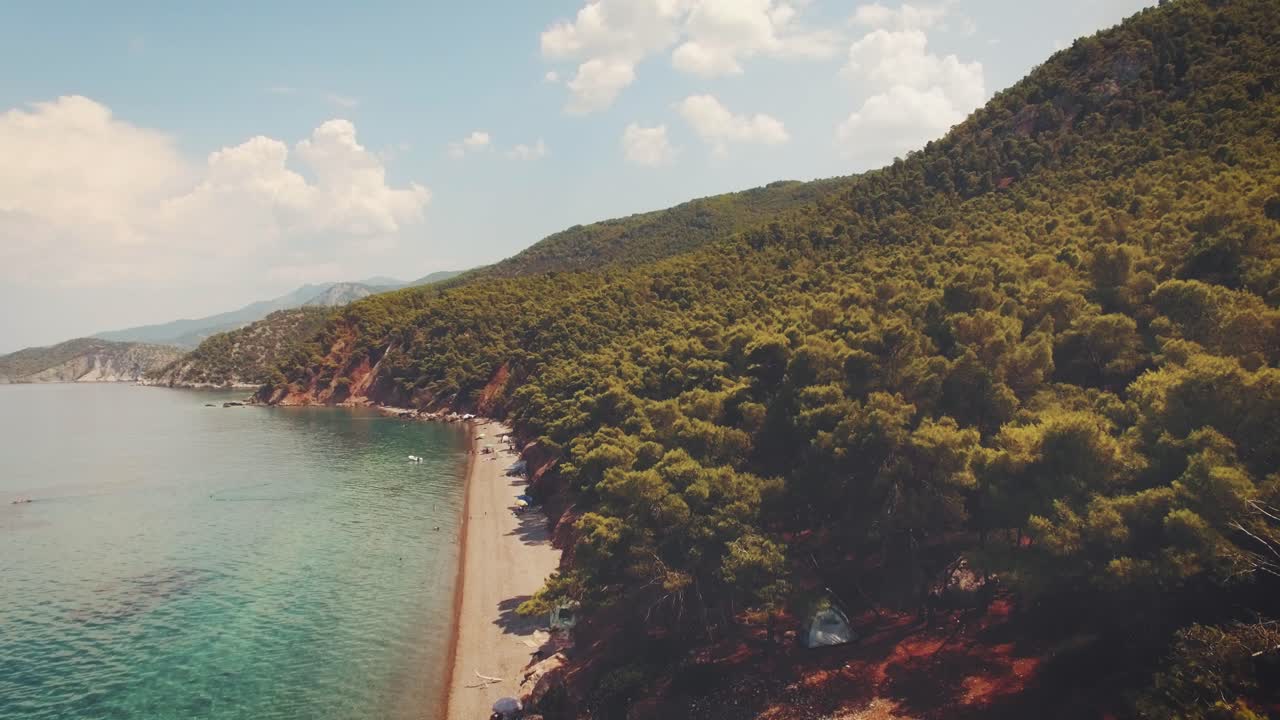 aerial footage of an exotic beach with crystal clear turquoise waters in Greece at summer 6