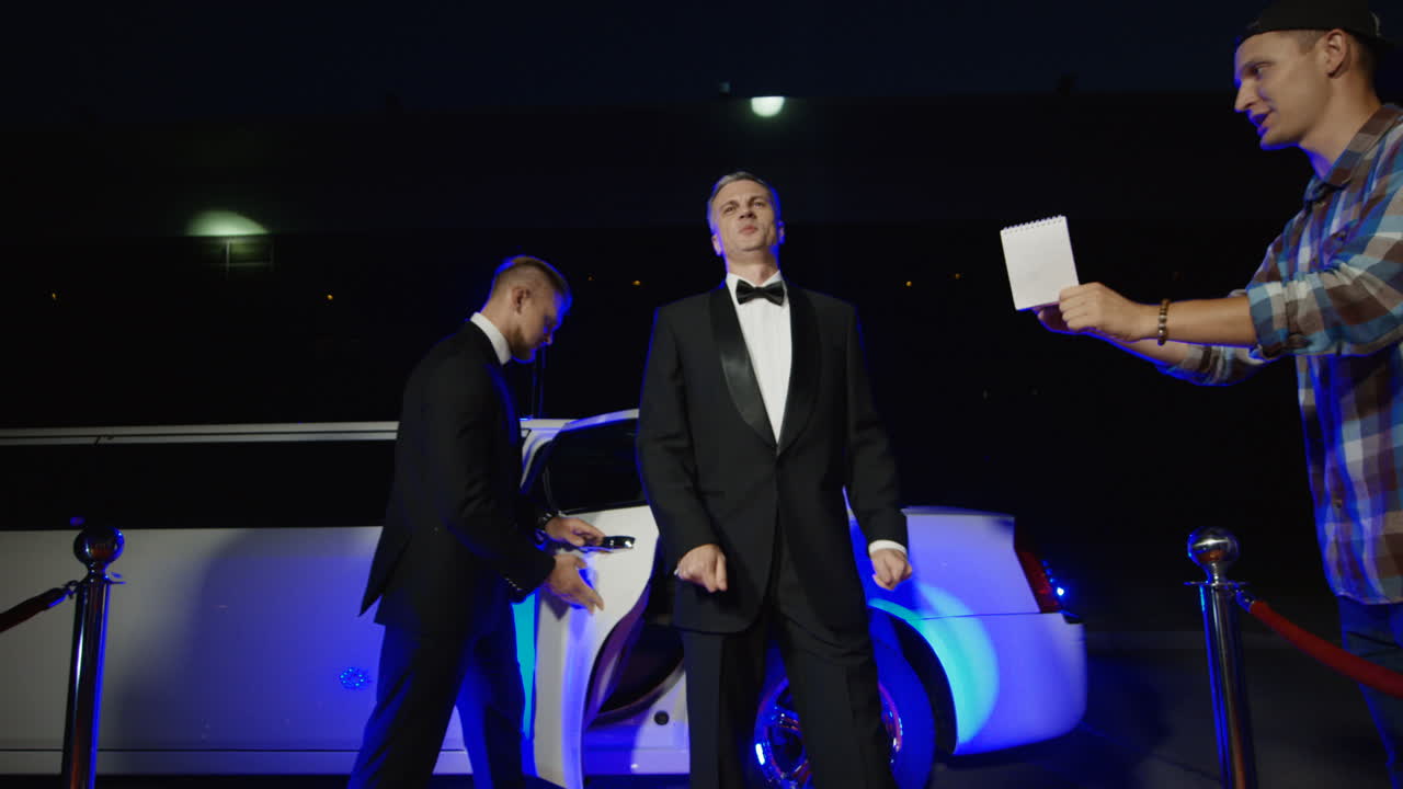 A celebrity interacts with fans and paparazzi on the red carpet