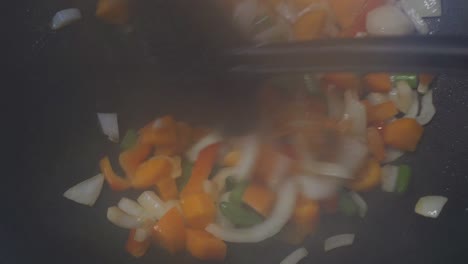 close up of cooking fresh vegetables in wok, steamy stir fry, colorful