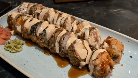 delicious japanese tuna maki roll with wasabi and cream sauce served on a plate in a restaurant