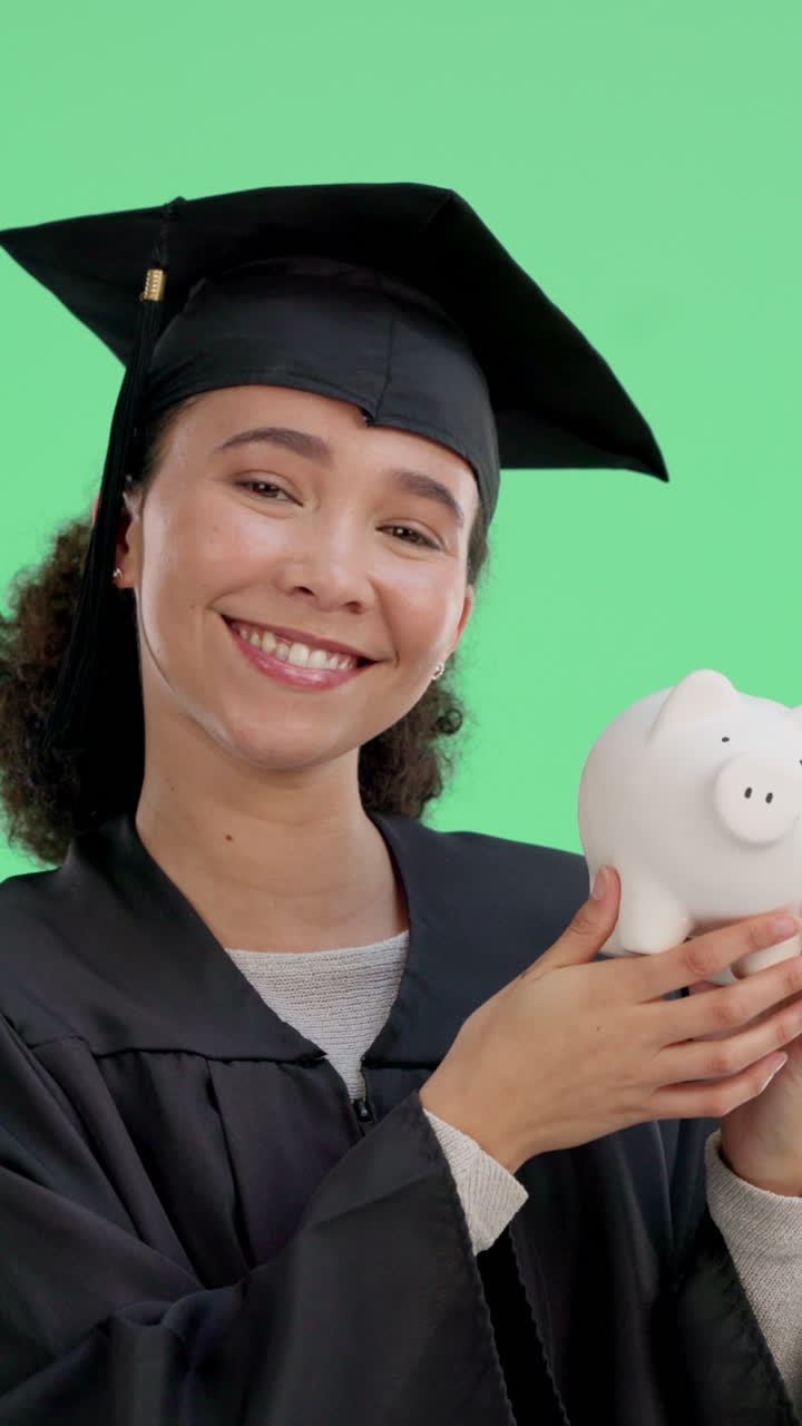 Mujer graduada feliz sosteniendo una hucha sobre pantalla verde