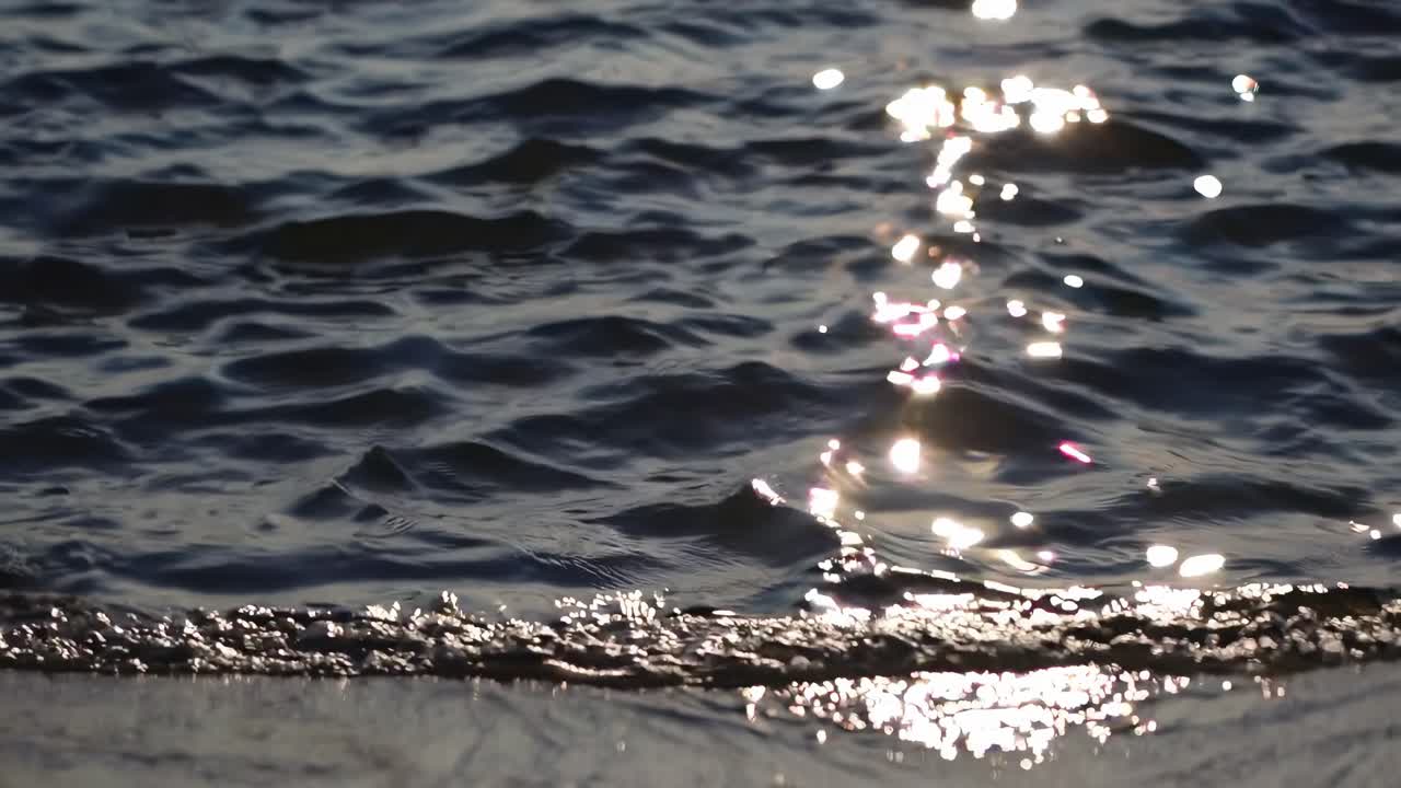 A serene video capturing the ocean's surface at sunset