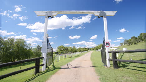 Slowly-Driving-Through-Grand-Archway-Over-Driveway-To-Horse-Ranch,-4K