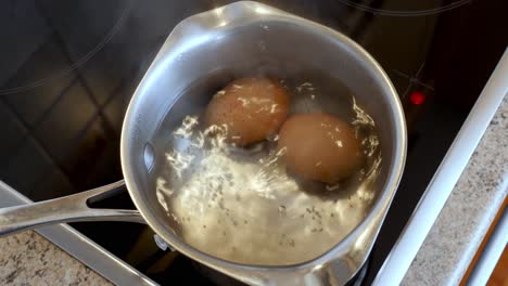 two eggs boiling in a pan